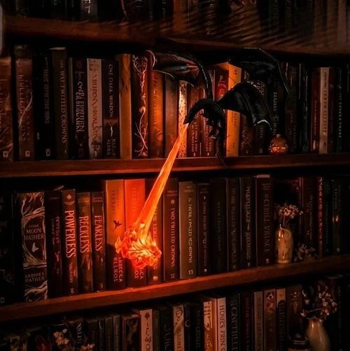 Dragon Book Lamp glowing on a bookshelf at night